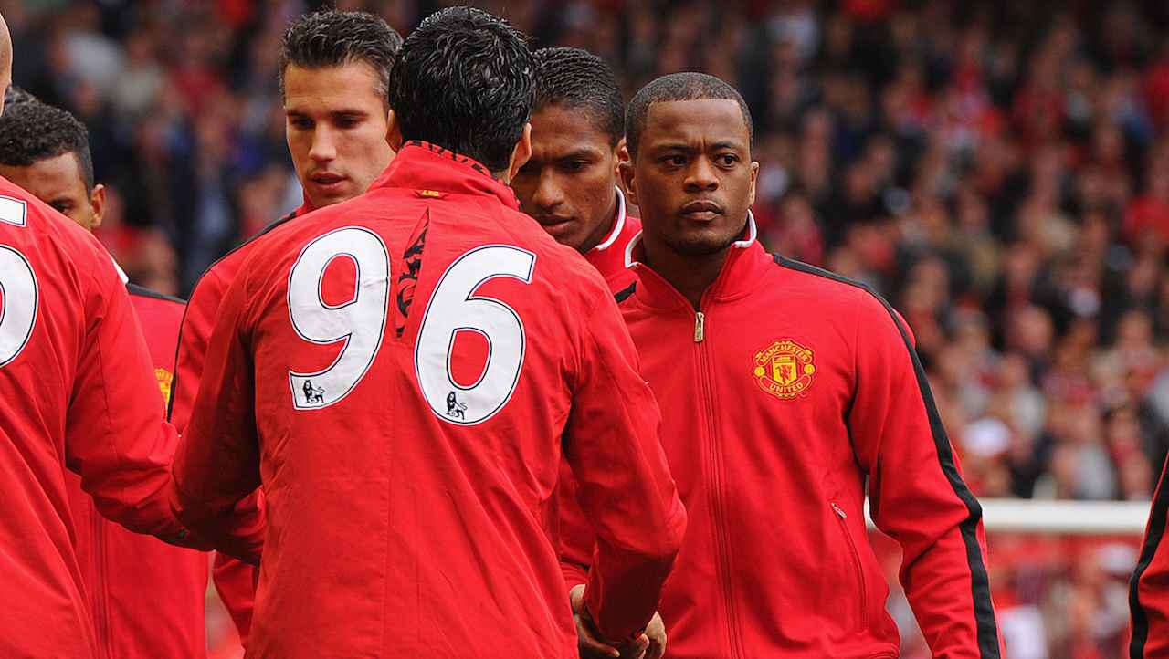 Evra stringe la mano a Luis Suarez