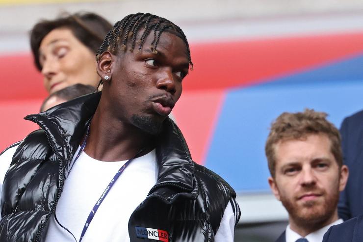 Paul Pogba  in abiti borghesi osserva