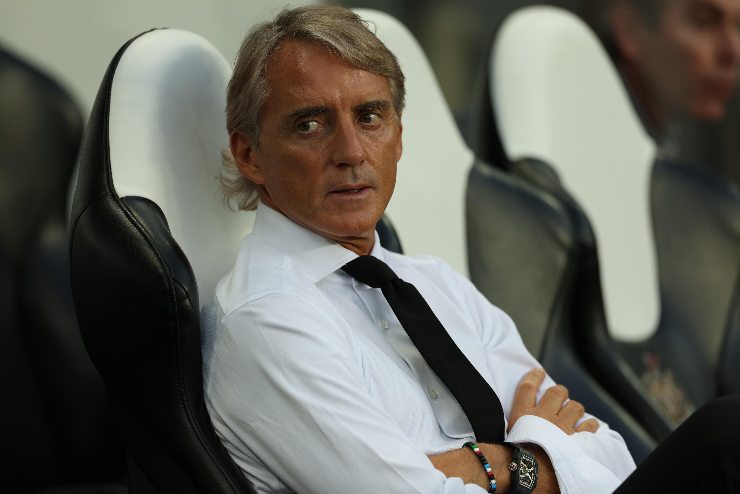 Roberto Mancini seduto in panchina in camicia con le braccia incrociate