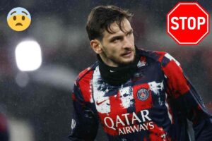 Kvicha Kvaratskhelia con la maglia del PSG e un cartello STOP