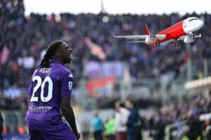 Moise Kean, attaccante della Fiorentina, esulta dopo un gol: sopra di lui un aereo