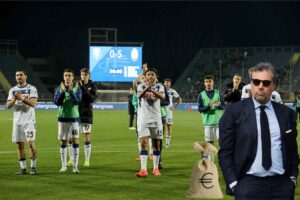 Giuntoli in primo piano e sullo sfondo i calciatori dell'Atalanta